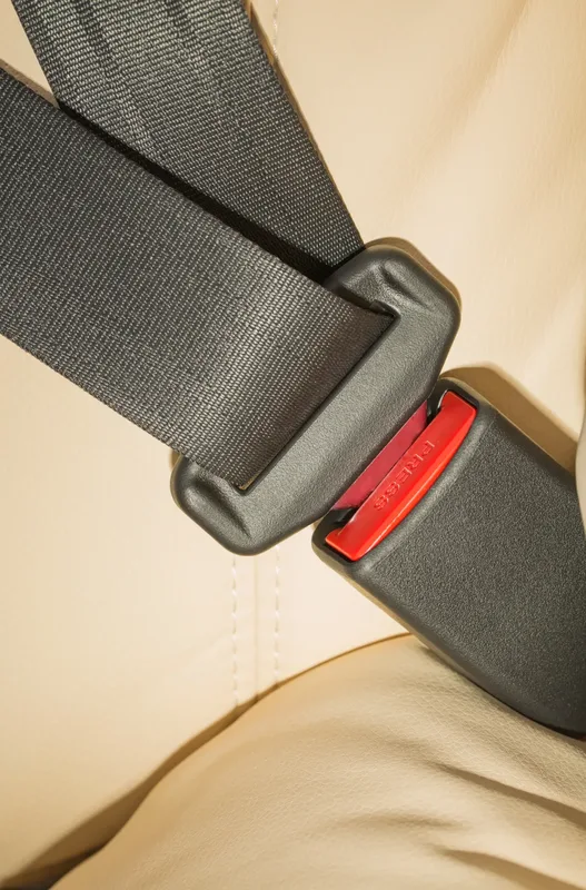 Seat belt webbing passing through a moulded guide loop above a vehicle seat