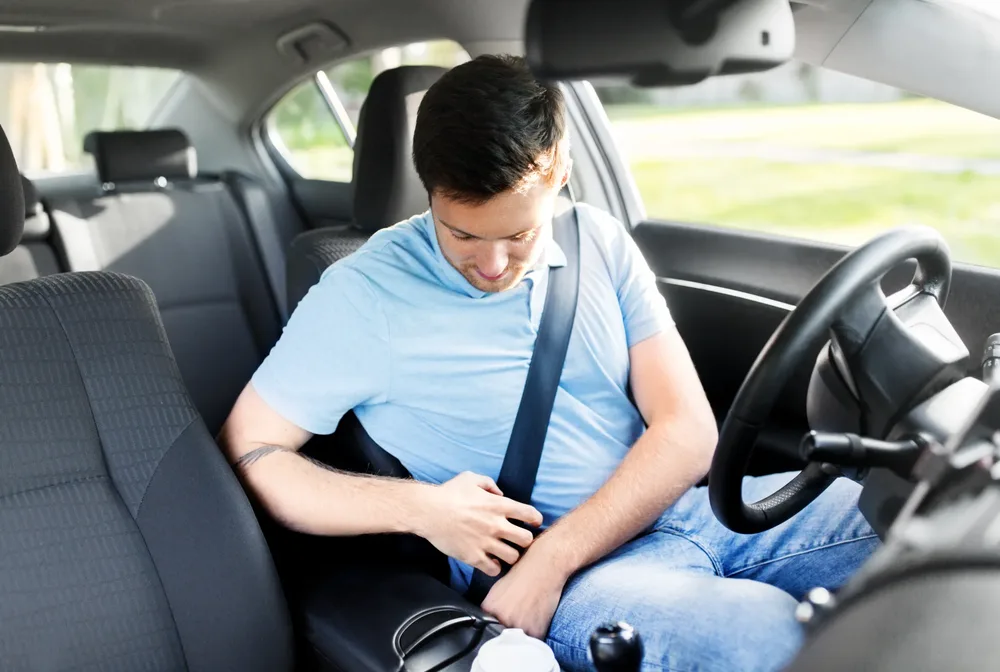 Occupant fastening a seat belt inside a vehicle cabin